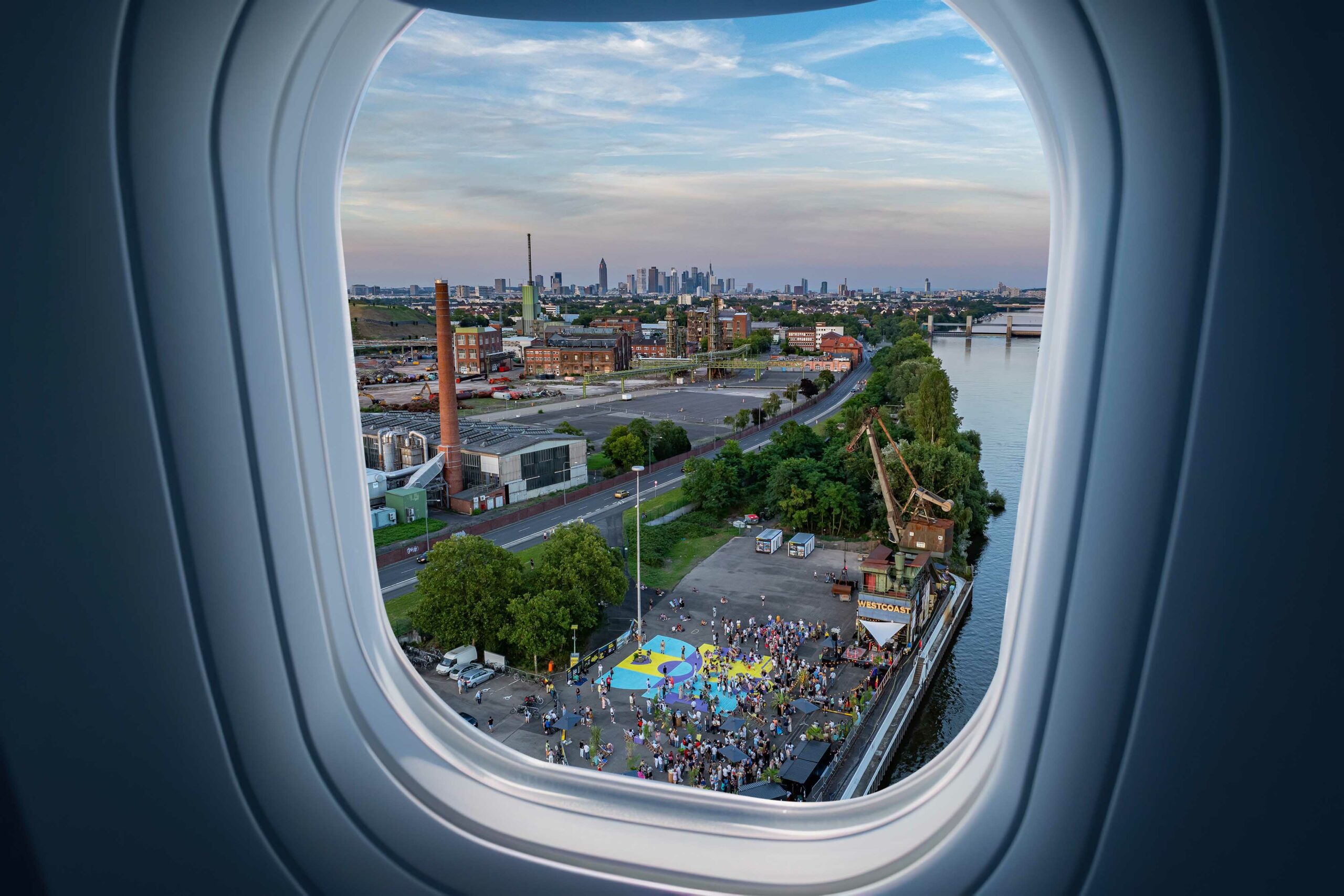 Eine S-Bahn-Station mit der Frankfurter Skyline im Hintergrund, von der aus man zur FRANKFURT WESTSIDE gelangt.